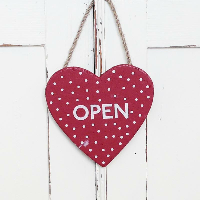 Red heart-shaped signage that says “Open”