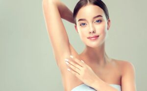 Fair-skinned woman with blue eyes caressing her exposed underarms